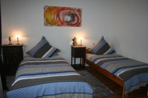 2 camas en una habitación con 2 lámparas en las mesas en Moderne Ferienwohnung mit Balkon im schönen Saarland, en Pachten