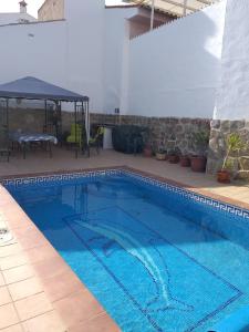 ein blauer Pool mit einem Tisch und einem Sonnenschirm in der Unterkunft Casa De Royal Oaks in Encinas Reales