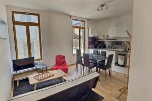 a kitchen and living room with a table and chairs at Des appartements au calme dans un immeuble historique in Béziers