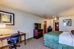 a hotel room with a desk and a bed and a computer at Cobblestone Inn & Suites - Waverly in Waverly
