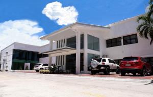 a white building with cars parked in front of it at My North Star Hotel in Tarlac