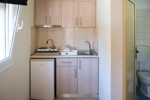 a small kitchen with wooden cabinets and a sink at Villa Filimon in Nea Vrasna +183 photos