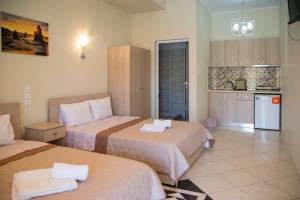a hotel room with two beds and a kitchen at Villa Filimon in Nea Vrasna