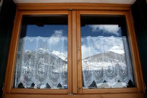 a window with lace curtains on a house at Chalet Presanella in Temù