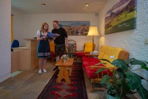a man and a woman standing in a living room at Seehotel Weissensee in Füssen