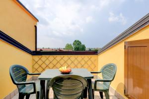 einen Tisch und Stühle auf einem Balkon mit Fenster in der Unterkunft Sarno Apartments Caravaggio in Sirmione