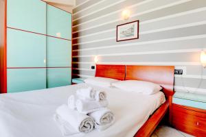 ein Schlafzimmer mit einem Bett mit Handtüchern darauf in der Unterkunft Sarno Apartments Caravaggio in Sirmione