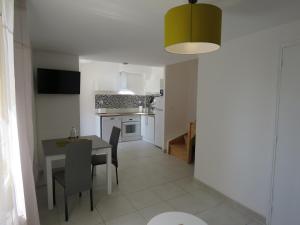 a kitchen and dining room with a table and chairs at Appartement centre historique avec Terrasse au porte de la Camargue in Saint-Gilles