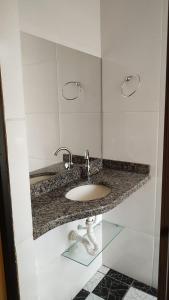 a bathroom with a sink in a white wall at Vitória Center Plaza Praça in Nova Friburgo +89 photos