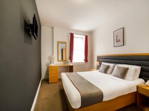 a bedroom with a large bed and a window at OYO London Luton in Luton