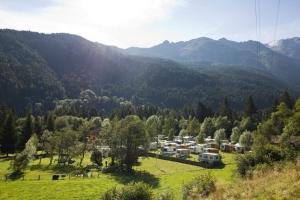 a group of rvs parked in a field in the mountains at Chalet Presanella in Temù