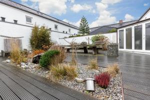 un patio con un banco de madera y un edificio en James Home, en Kampen