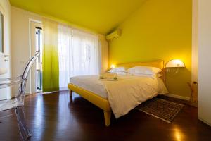 una camera con un letto con una parete gialla di L'Angolo di Lore B&B a Fano