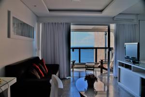 a living room with a couch and a tv at Seaflats Iracema Residence in Fortaleza
