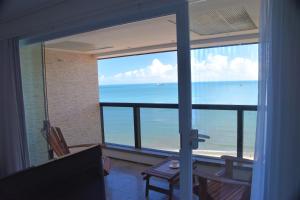 a room with a view of the ocean from a window at Seaflats Iracema Residence in Fortaleza
