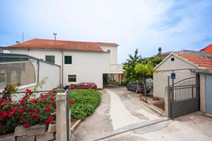 a driveway of a house with a gate and flowers at Apartment Marsela in Šibenik