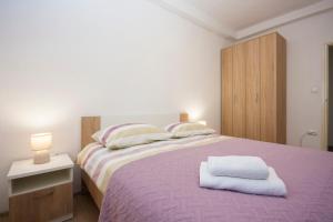 a bedroom with a large bed with a purple blanket at Apartment Marsela in Šibenik