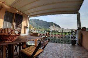 a patio with a table and chairs and a view of a mountain at B&B Cribò in San Giuliano Terme