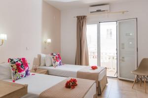 a hotel room with two beds and a balcony at Emerald Hotel in Malia