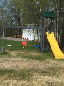 a playground with two slides and a swing at motel Christine in Lac-Bouchette