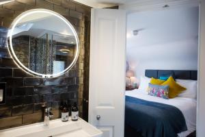 um quarto com uma cama, um espelho e um lavatório em Moortown Lodge B&B em Ringwood