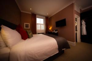 a bedroom with a large white bed with red pillows at Moortown Lodge B&B in Ringwood