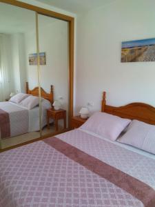 a bedroom with two beds and a large mirror at Apartamento en La Cala in Cala de Finestrat