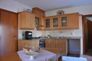 a kitchen with wooden cabinets and a table with a bowl on it at Casa Mouramortina in Vila Nova de Poiares