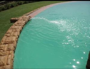 a large pool of water with a stone wall at Ocean View Villas Unit A11 in Port Edward