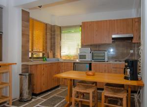 a kitchen with wooden cabinets and a wooden table at Apollonia Hotel Apartments in Varkiza
