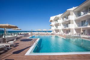 a swimming pool in front of a building at Grupotel Picafort Beach in Can Picafort