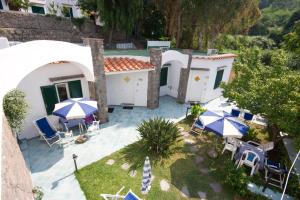 un patio esterno con ombrelloni e sedie blu e bianche di Hotel Oasi Castiglione a Ischia