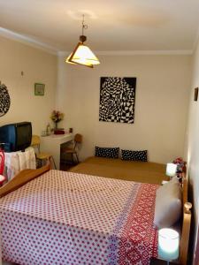 a bedroom with a bed with a red and white blanket at Templar Secrets House in Tomar