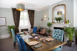 a dining room with a table and blue chairs at Moortown Lodge B&B in Ringwood