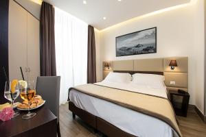 une chambre d'hôtel avec un lit et une assiette de nourriture sur une table dans l'établissement Hotel Palazzo Argenta, à Naples