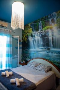 1 dormitorio con un mural de cascada en la pared en Orestis House, en Artemida