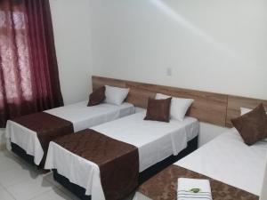 two beds in a hotel room with at Porto Seguro Office Hotel in Bauru