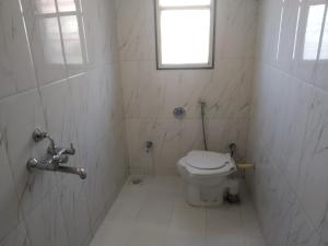 biała łazienka z toaletą i oknem w obiekcie Ashoka Villa 3 BHK Mahabaleshwar w mieście Mahabaleshwar