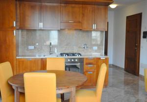 a kitchen with a wooden table and yellow chairs at Appartamenti fronte mare in Castiglioncello