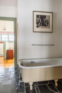 a bath tub in a bathroom with a picture on the wall at Whitford House and Twin View Barn in Addison