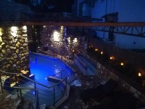 a swimming pool at night with lights on a building at Skourtaniotis spa rooms in Loutra Edipsou