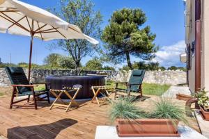 a patio with two chairs and an umbrella at V&A House in Vinkuran