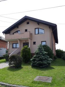a house with a tree in the front yard at Apartman Kristian in Velika Gorica