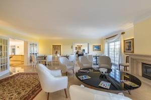 Estoril Luxury Suites & Spa - Cascais في استوريل: غرفة معيشة مع طاولة وكراسي ومدفأة