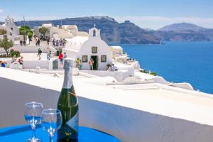 a bottle of wine sitting on top of a white table at Stelios Rooms in Oia
