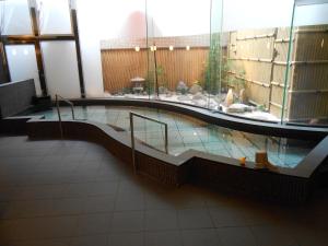 
a bathroom with a tub, sink, and mirror at Niigata Daiichi Hotel in Niigata
