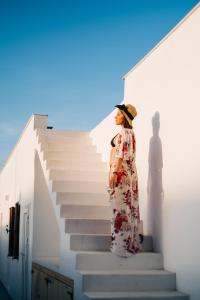 a woman standing next to a staircase with a shadow at Mesanto Luxury Suites in Megalochori