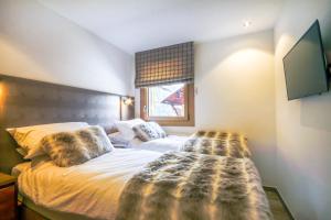 a bedroom with a bed with a blanket on it at PORTES DU PLENEY 101 in Morzine
