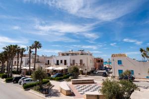 a view of a street with buildings and palm trees at Residence Marinella in San Vito lo Capo