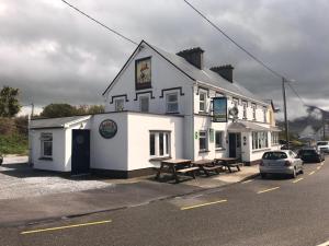 a white building with a picnic table in front of it at Westend Bar & select accommodation in Fenit
